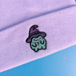 Bonnet lavande à revers brodé d'une grenouille mignonne déguisée en sorcière, fil pailleté, thème Halloween