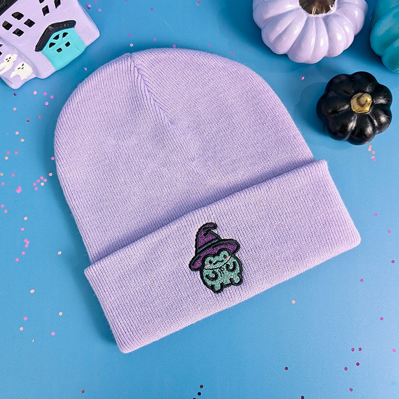 Bonnet à revers rose pastel brodé d'une grenouille kawaii en sorcière, fil pailleté, édition Halloween