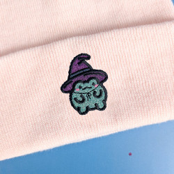 Bonnet à revers avec broderie grenouille kawaii sorcière en fil pailleté, disponible en rose pastel, lavande et noir