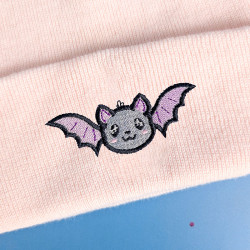 Bonnet à revers rose pastel brodé d'une chauve-souris kawaii, motif Halloween