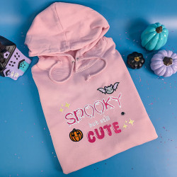 Sweat rose pâle brodé 'Spooky but still cute' avec citrouille et chauve-souris kawaii